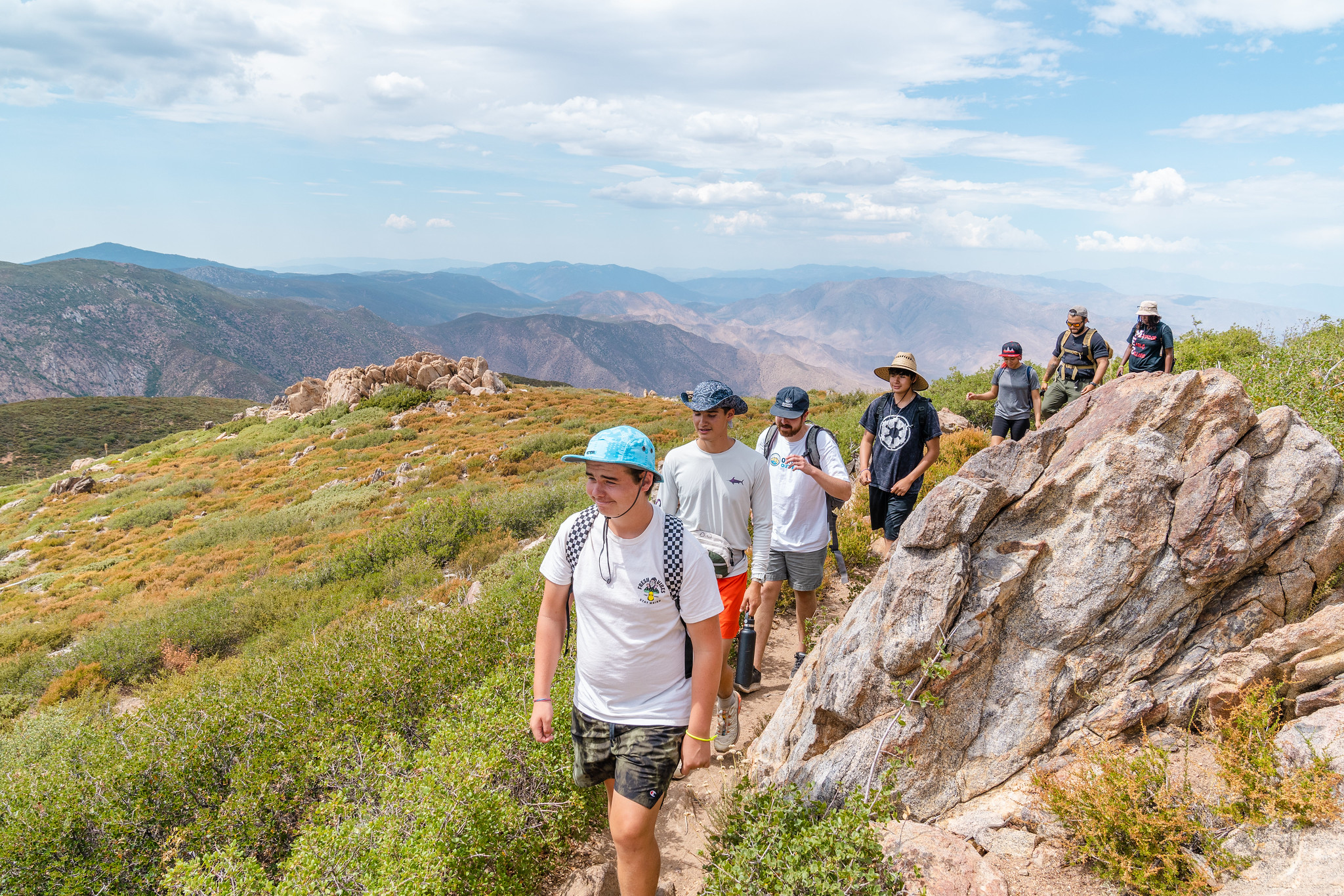 Youth hike along Garnet's Peak overlooking the purple Laguna Mountains 